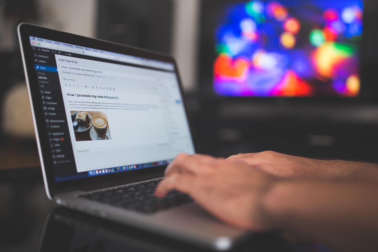 A wordpress website displayed on a laptop computer screen with hands typing on the keyboard